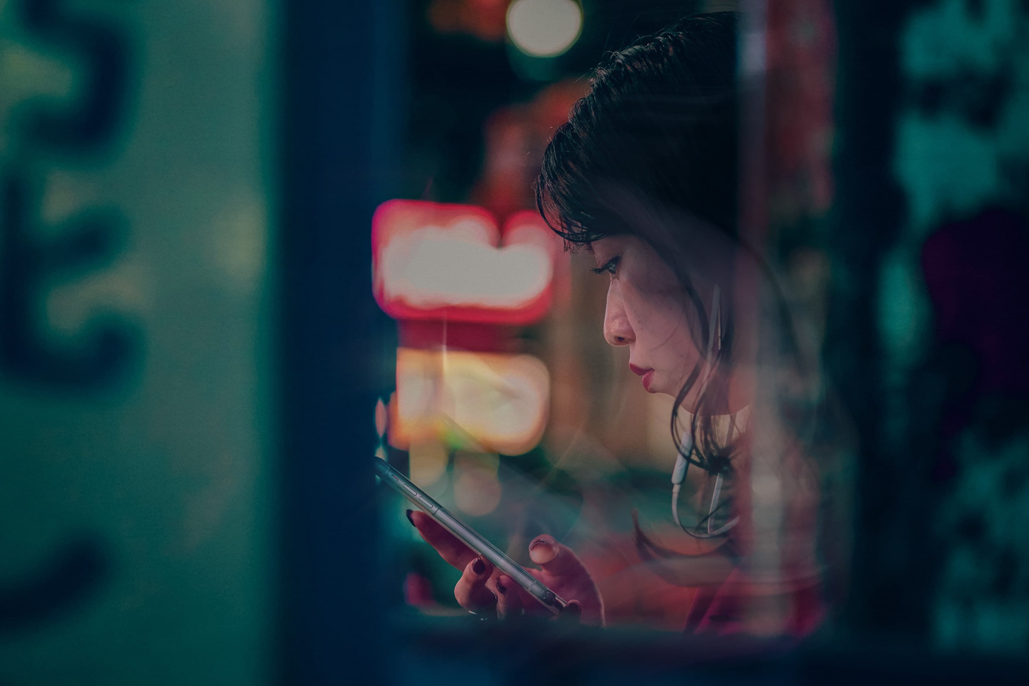 woman looking at phone with colourful background