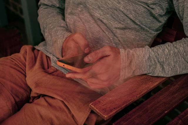 image of hands of man holding phone