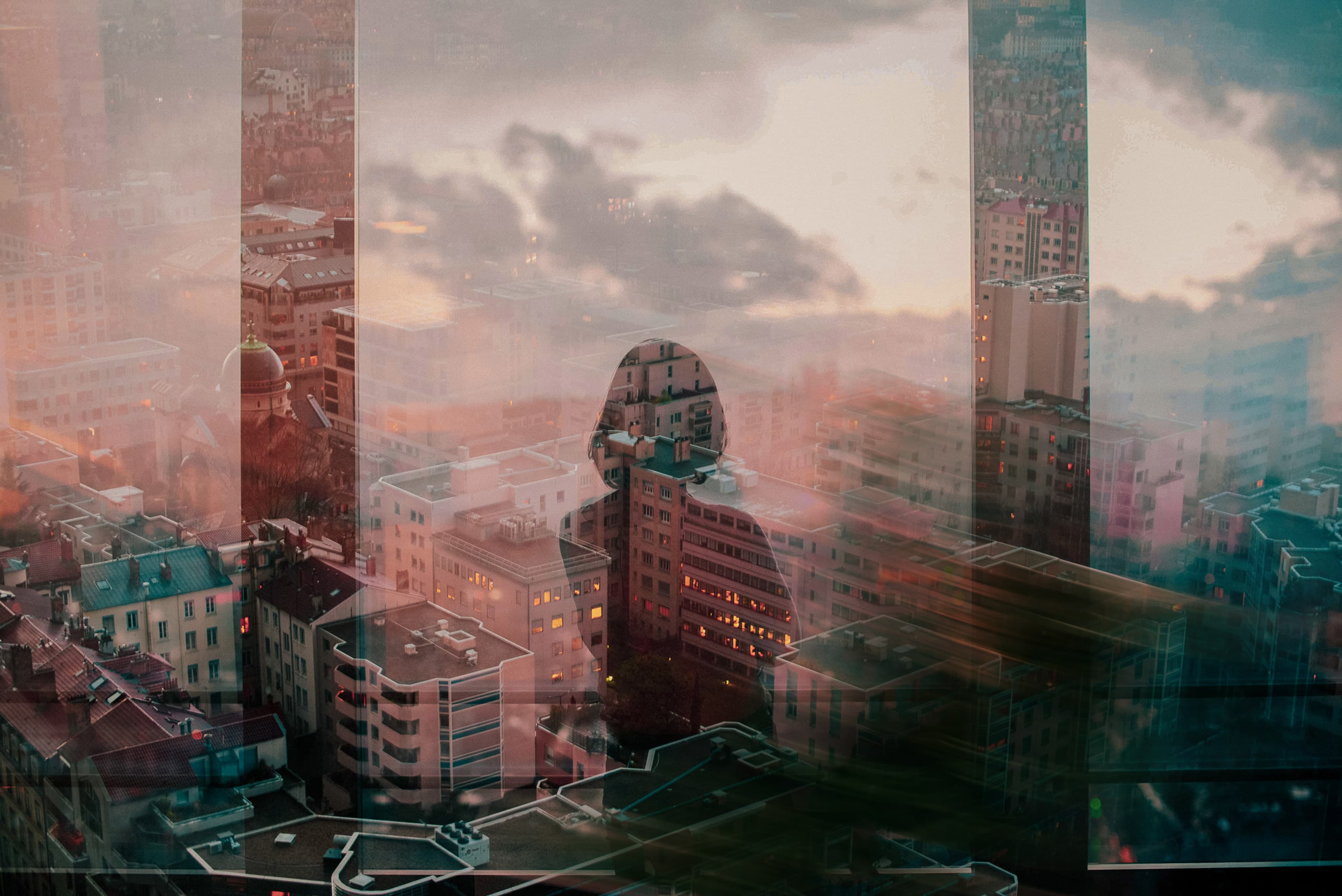 image of a woman looking out a window to a city skyline