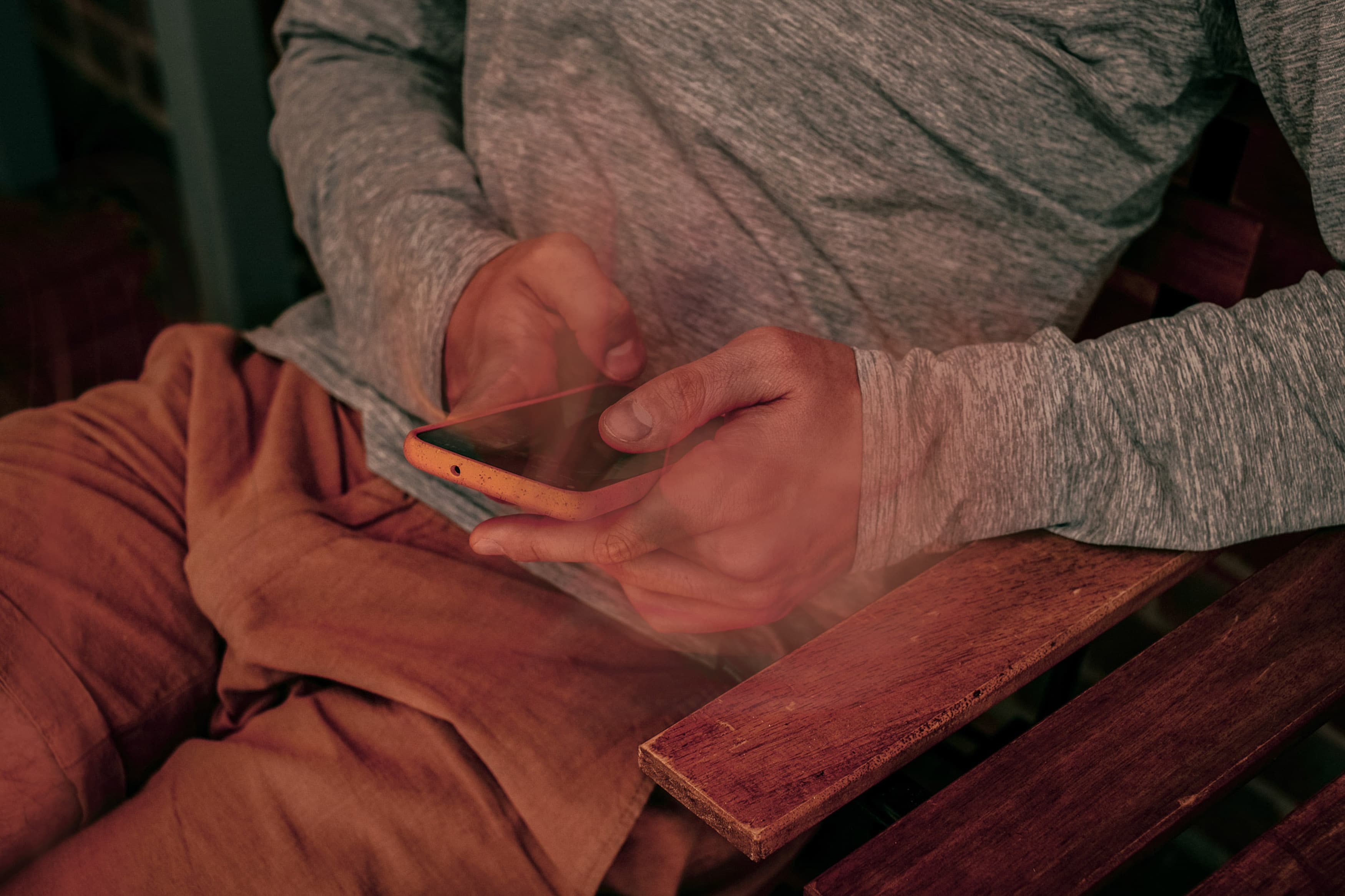 photo showing the hands of a man holding his phone